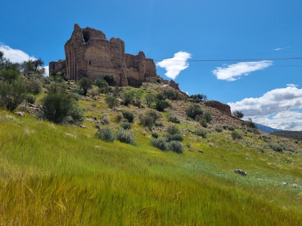 Qal‘eh Dokhtar, seen from the grassy slope below.