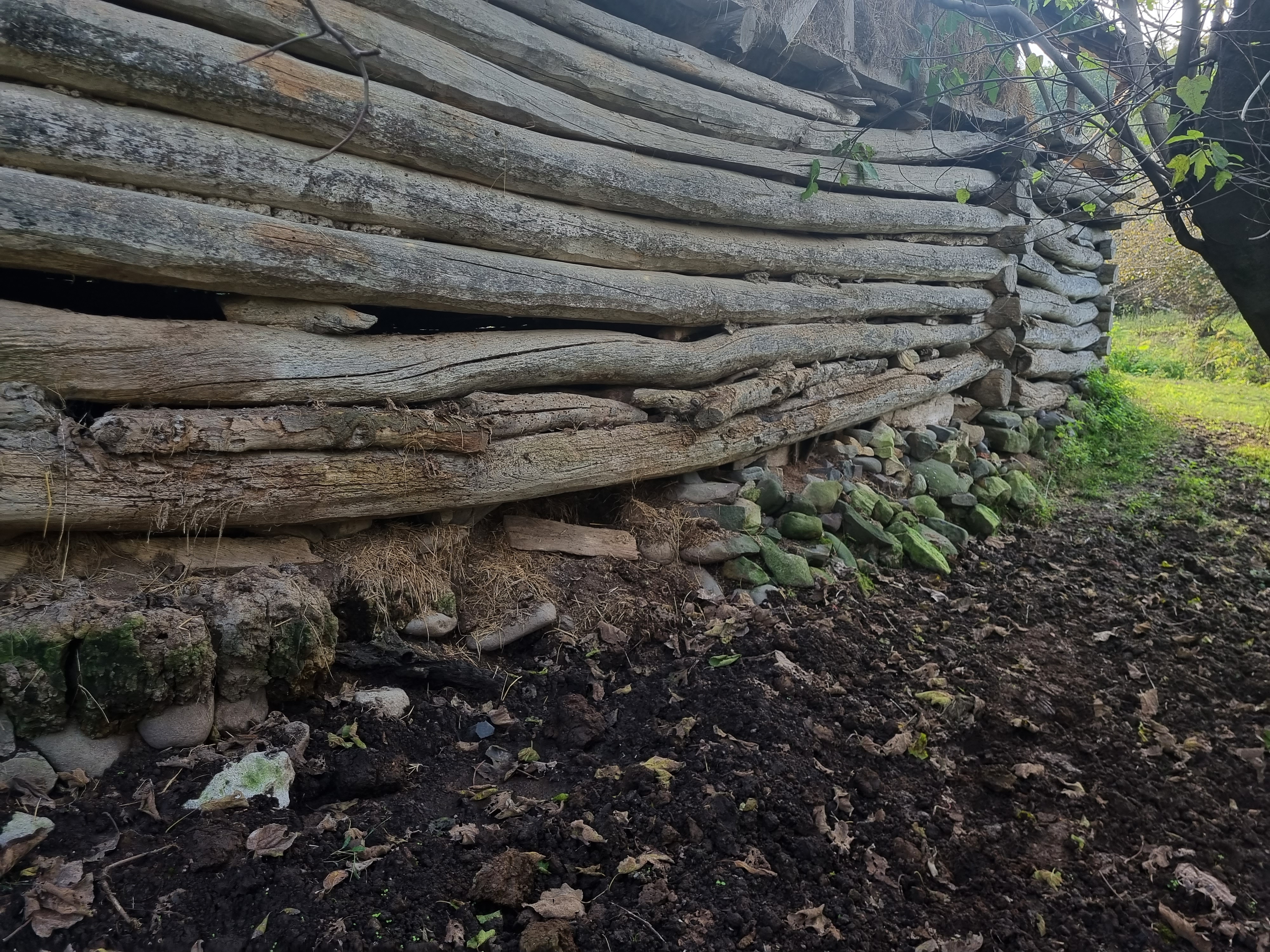 Original field photograph of the long Telar log wall and its stone bearing