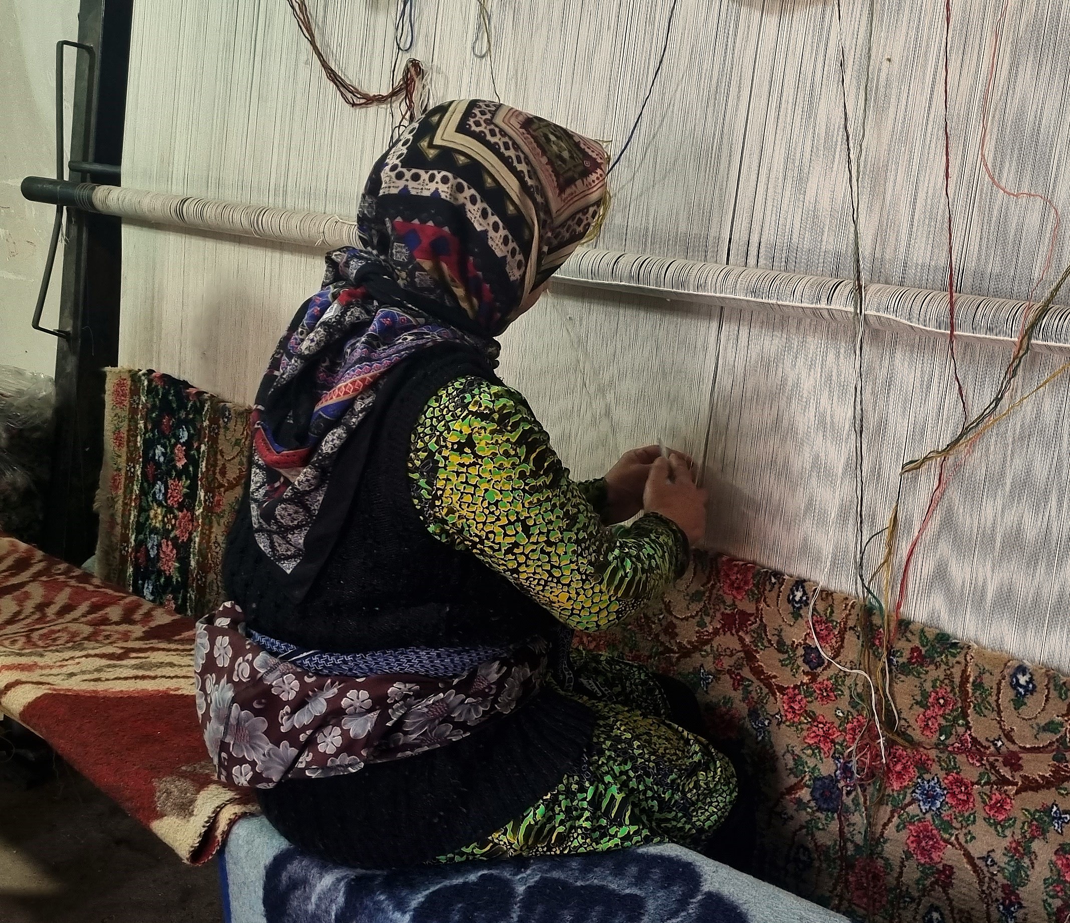 A woman working at a full carpet loom in Bijar, photographed by Kiarash Taheri