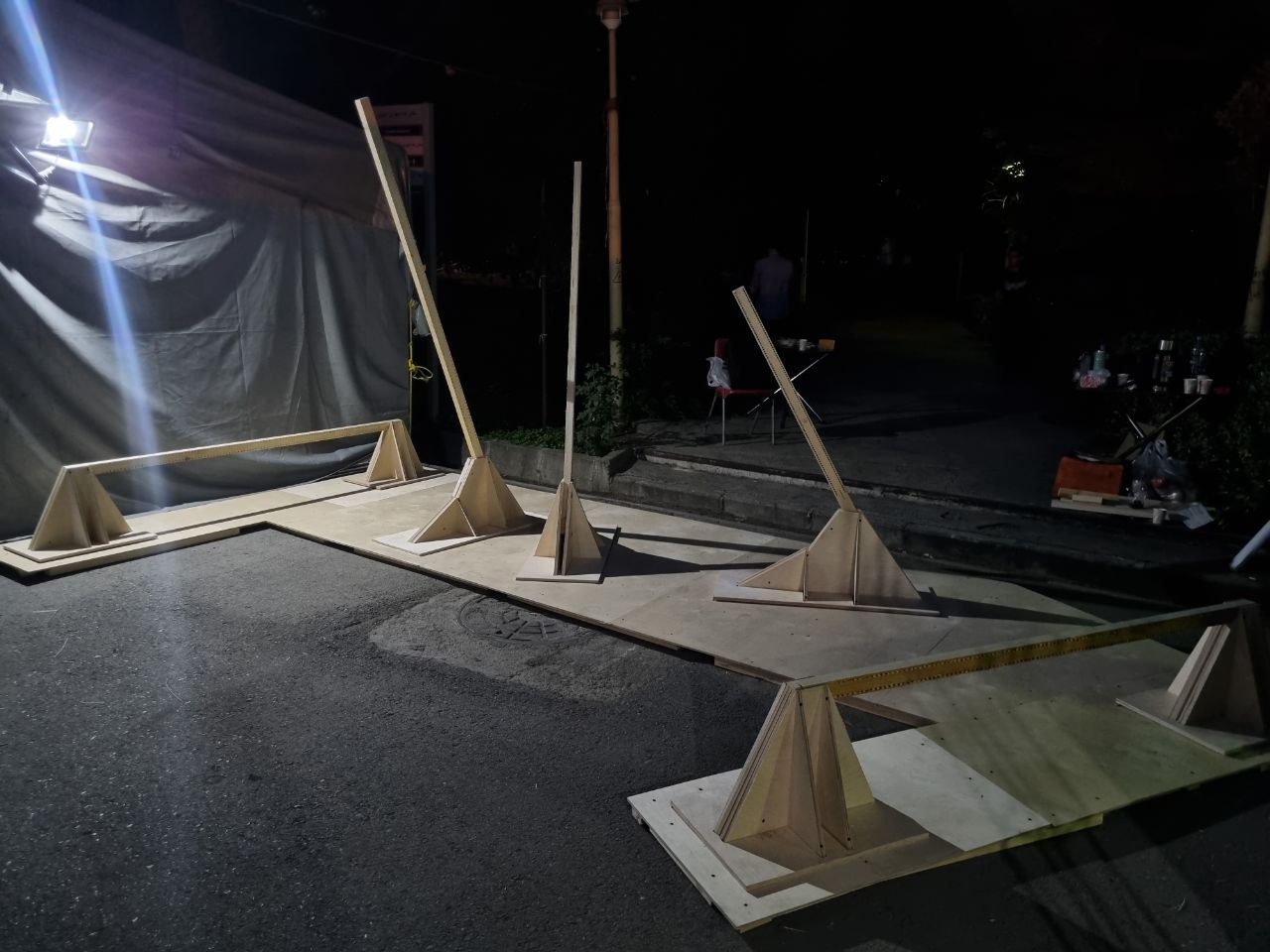 Bare timber frame and bases at night before threading
